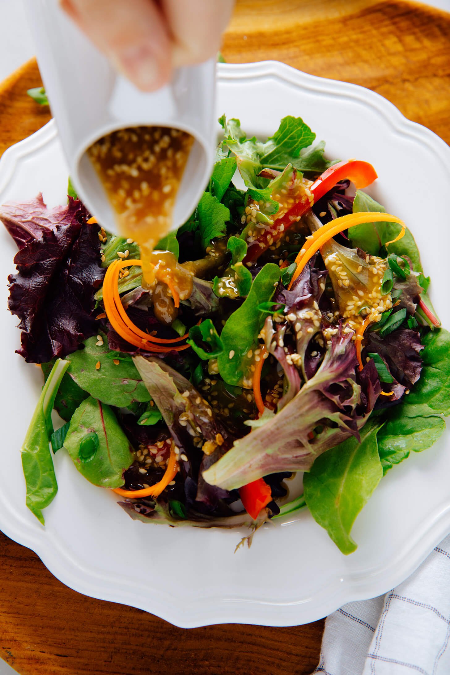 sesame dressing drizzling on salad